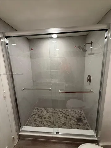 a bathroom with a shower and wooden floor