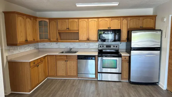 a kitchen with kitchen island granite countertop wooden cabinets and a stove