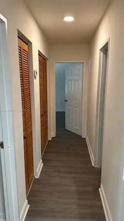 a view of a hallway with wooden floor