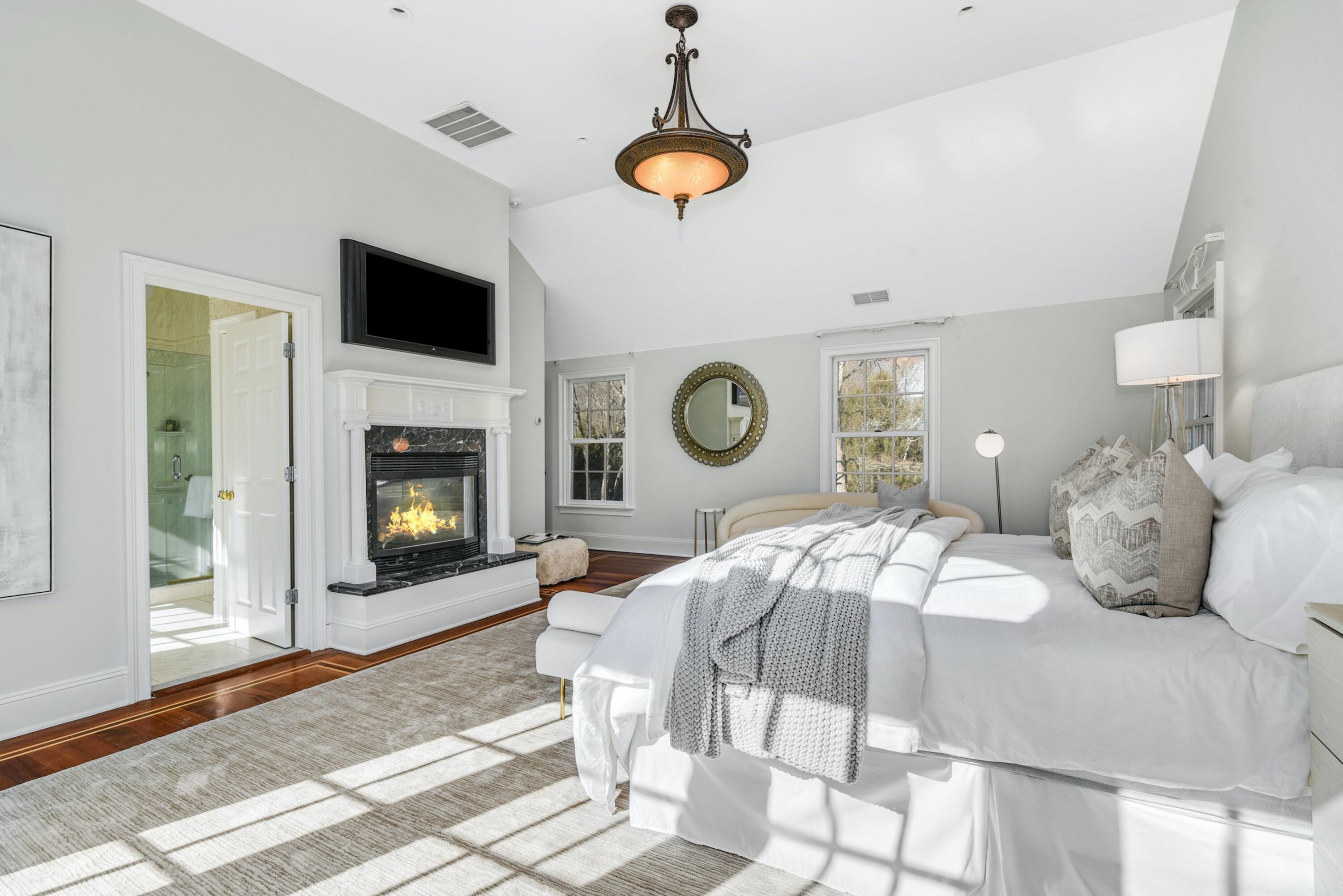 507 Trinity Pass Road New Canaan, CT 06840 - Photo 11 of 23 a bedroom with a bed a fireplace and a chandelier