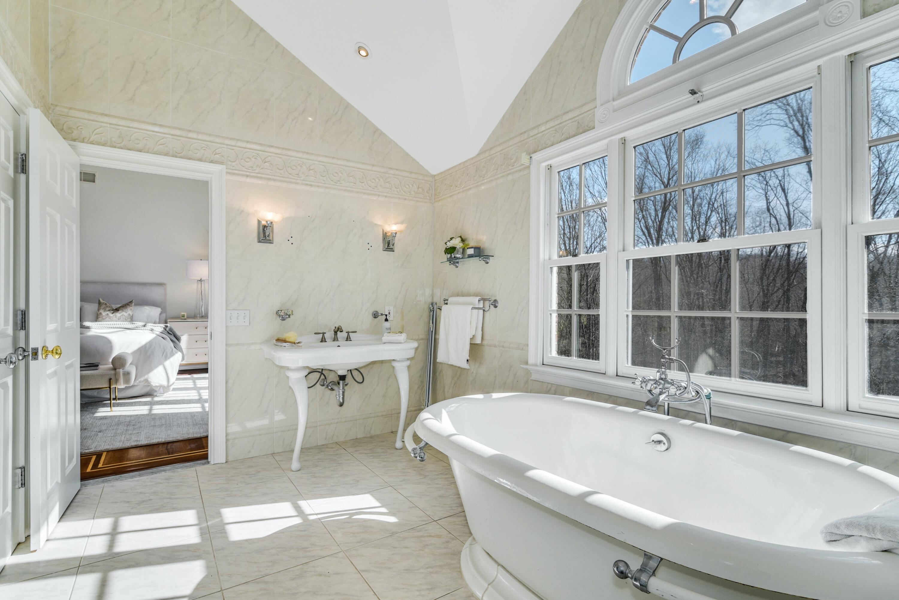 507 Trinity Pass Road New Canaan, CT 06840 - Photo 13 of 23 a bathroom with a tub a sink and a large mirror next to a window