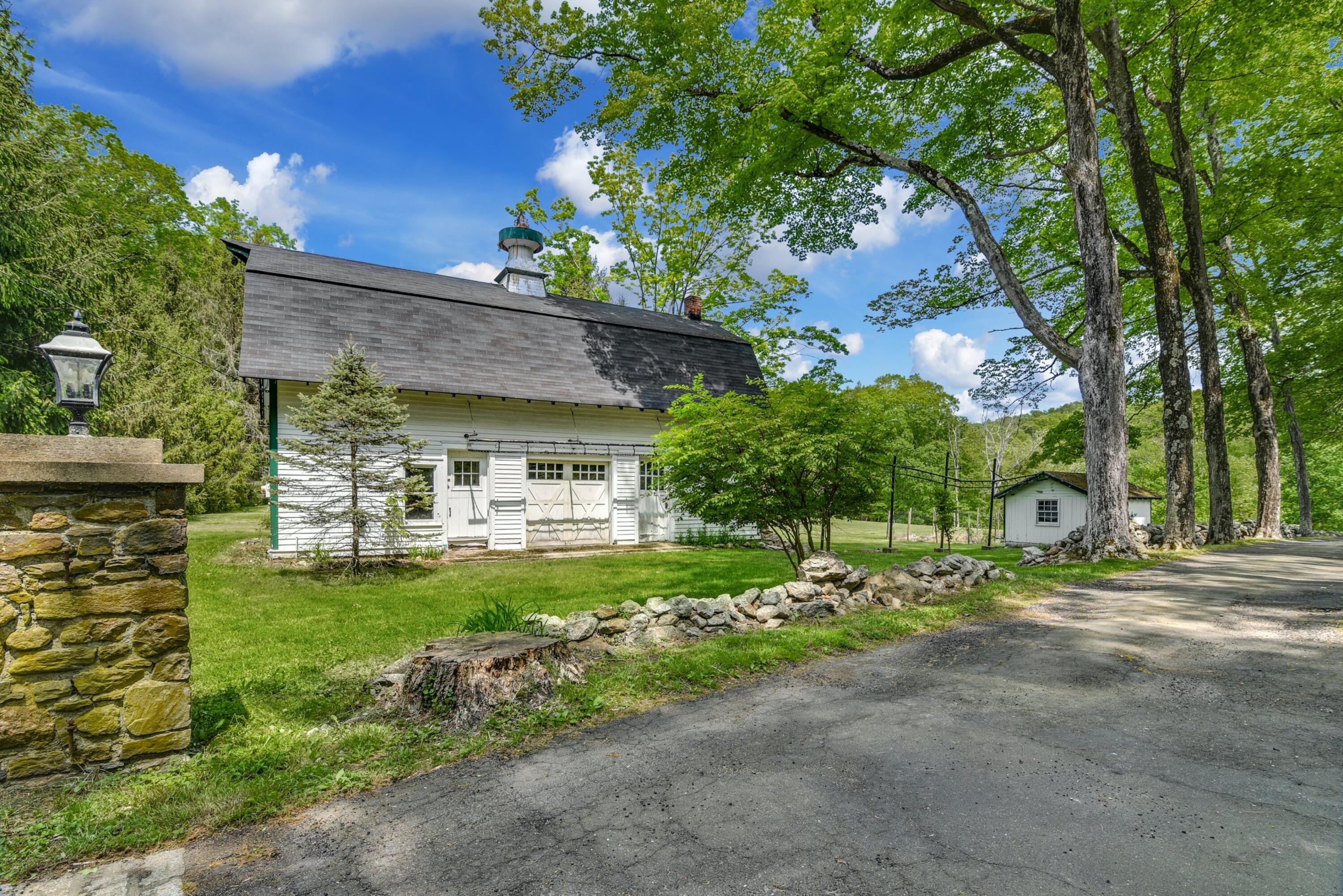 507 Trinity Pass Road New Canaan, CT 06840 - Photo 20 of 23 a front view of a house with a garden