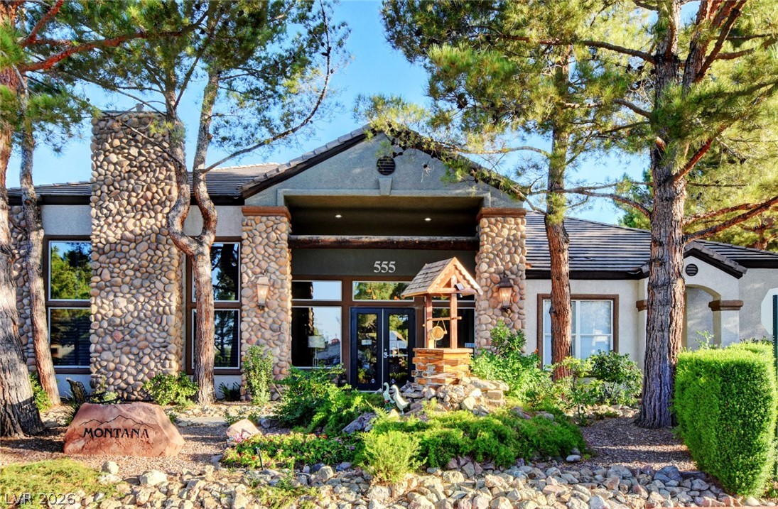 555 East Silverado Ranch Boulevard, Unit 2124 Las Vegas, NV 89183 - Photo 39 of 47 A welcoming stone-clad entrance framed by mature trees, hinting at rustic elegance.