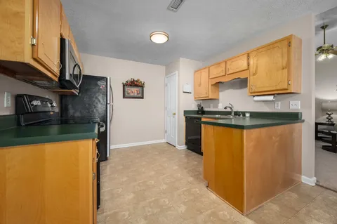 a kitchen with stainless steel appliances granite countertop a sink and a refrigerator