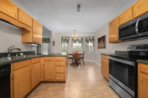 a kitchen with stainless steel appliances granite countertop a stove a sink and a microwave