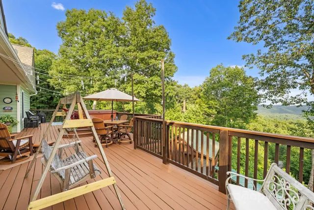 a view of swimming pool with a couches chairs and wooden fence