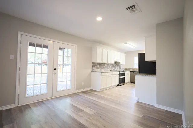 a kitchen with a refrigerator and a stove top oven