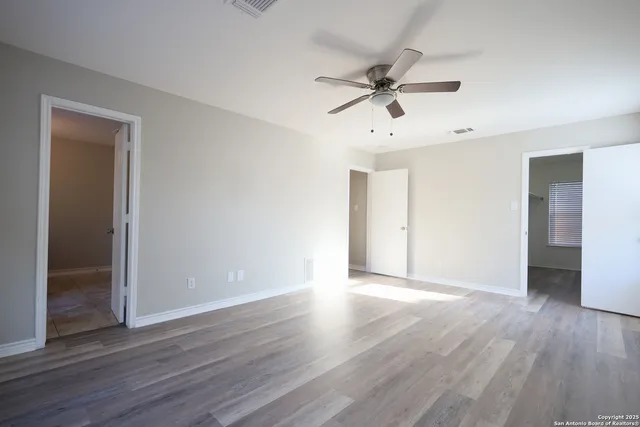 a view of an empty room with wooden floor