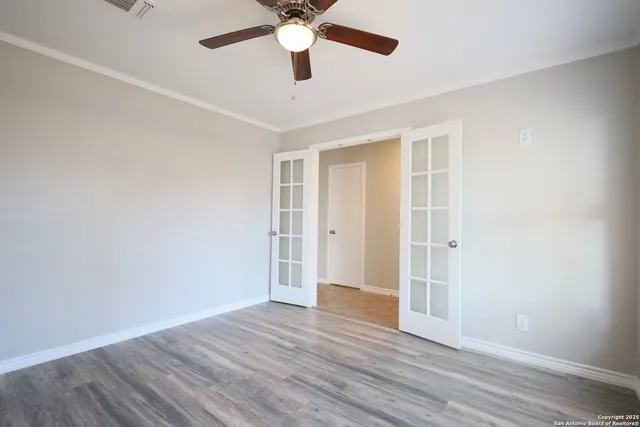 a view of an empty room with wooden floor