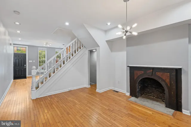 a view of a livingroom with a fireplace stairs and a chandelier