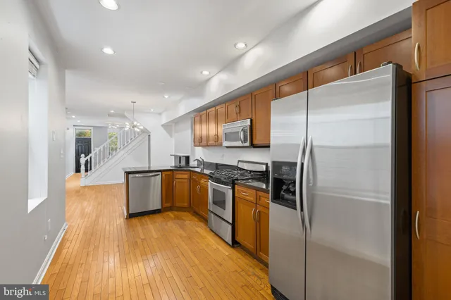 a kitchen with stainless steel appliances a refrigerator and a stove top oven