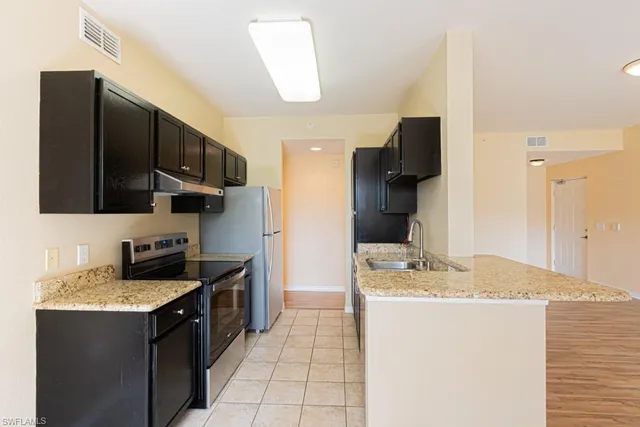 a kitchen with granite countertop a refrigerator and a stove