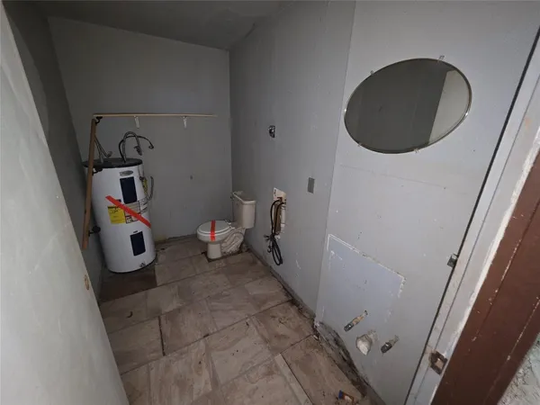 an empty room with windows and ceiling fan