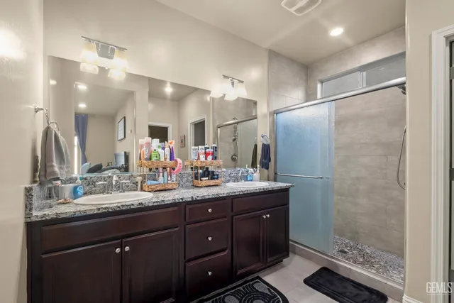 a bathroom with a double vanity sink mirror and shower