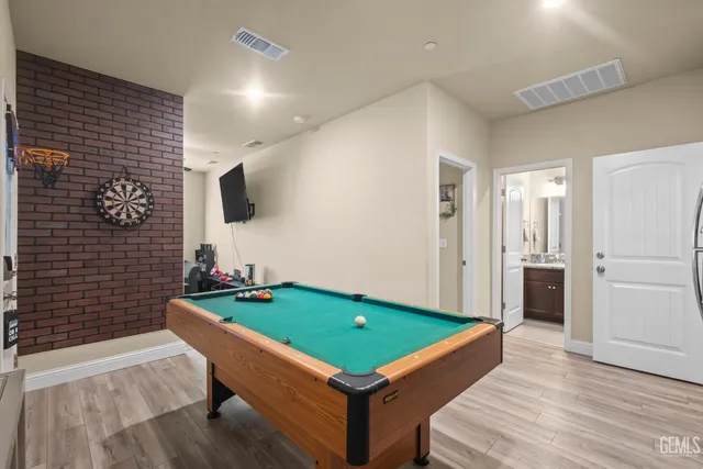 a room with pool table and windows