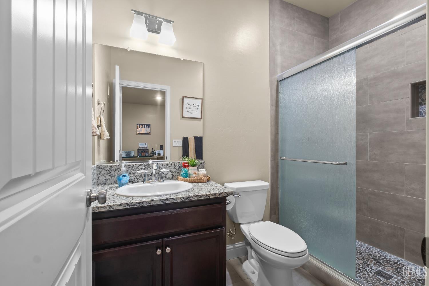 Undisclosed Address Shafter, CA 93263 - Photo 29 of 38 a bathroom with a granite countertop sink toilet a mirror and shower