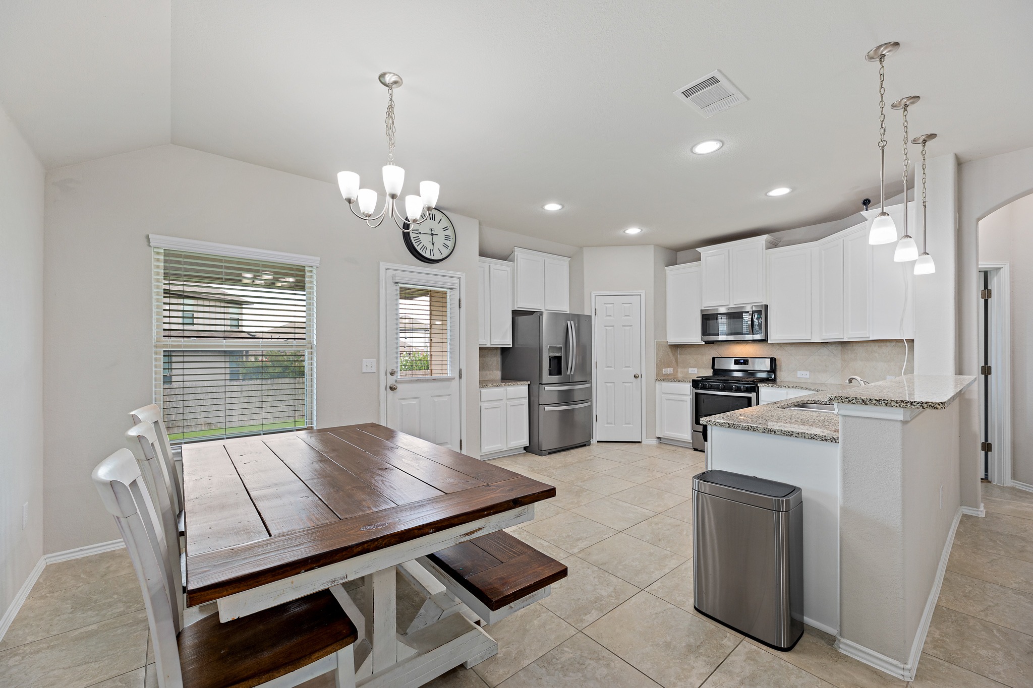382 Limerick Road Buda, TX 78610 - Photo 8 of 20 A well-appointed kitchen features stainless steel appliances, ample cabinetry, and a cozy breakfast area with charming pendant lighting.
