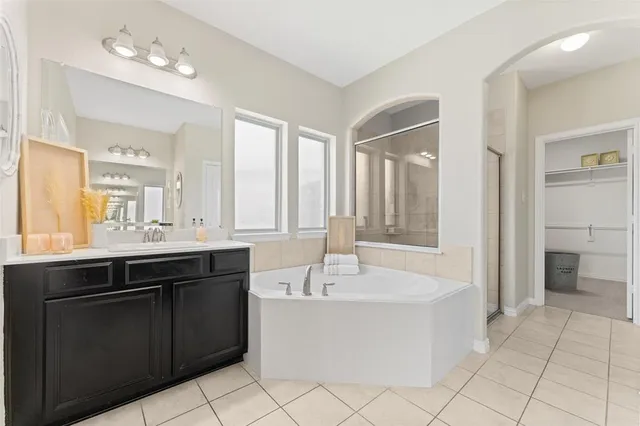 a bathroom with a tub sink and mirror