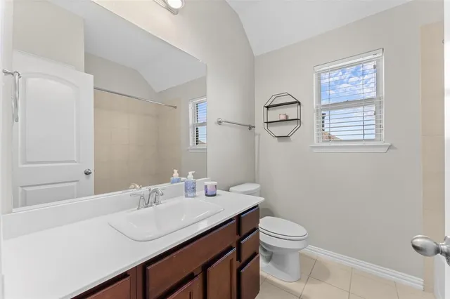 a bathroom with a granite countertop sink a toilet and a mirror