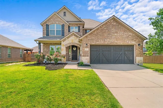 a front view of a house with yard and a garden
