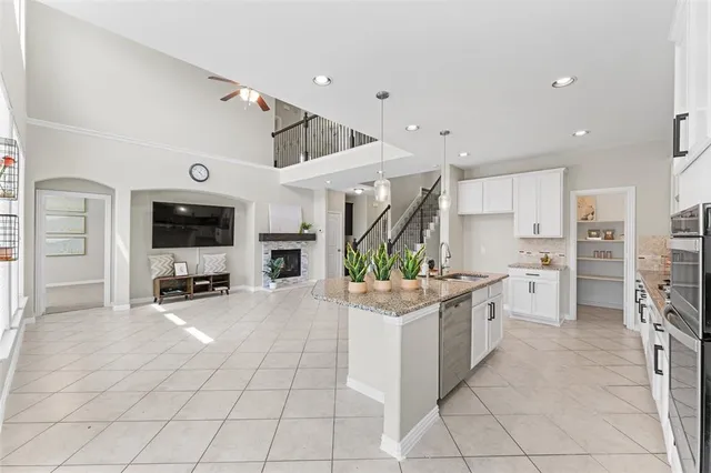 a kitchen with stainless steel appliances kitchen island granite countertop a refrigerator and a stove top oven