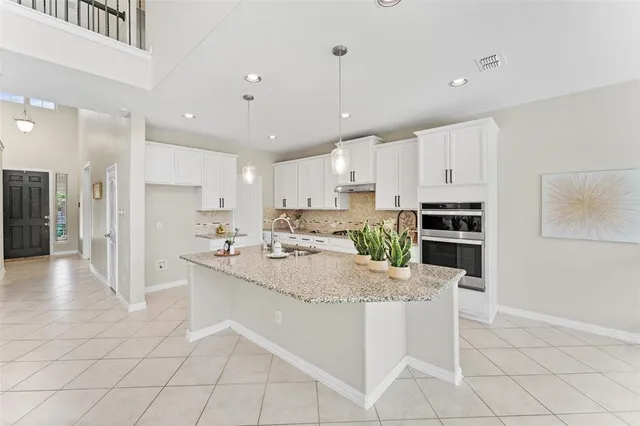 a large white kitchen with a stove a sink dishwasher and a refrigerator with wooden floor