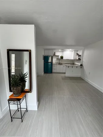 a living room with stainless steel appliances kitchen island granite countertop furniture and a fireplace