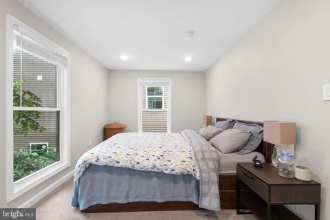 a bedroom with a bed a window and a lamp