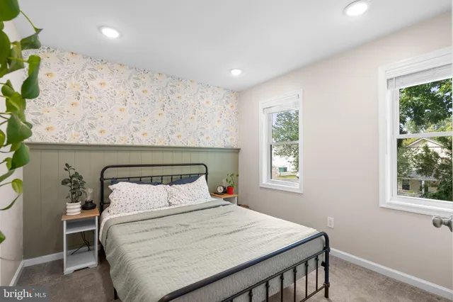 a bedroom with a bed a window and potted plant