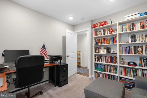 a view of a workspace with bookshelf and a workspace