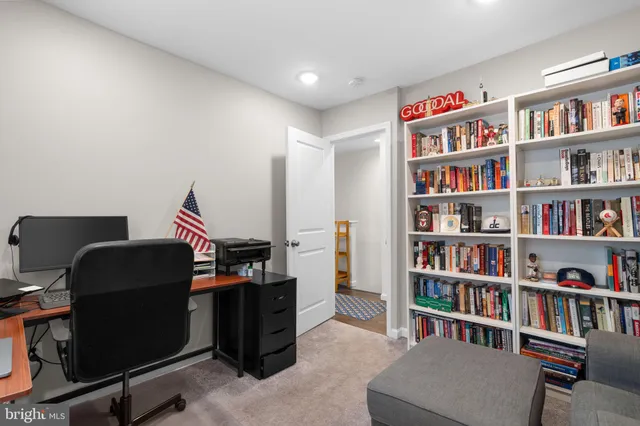 a view of a workspace with bookshelf and a workspace