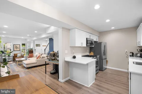 a living room with furniture a flat screen tv and a wooden floor