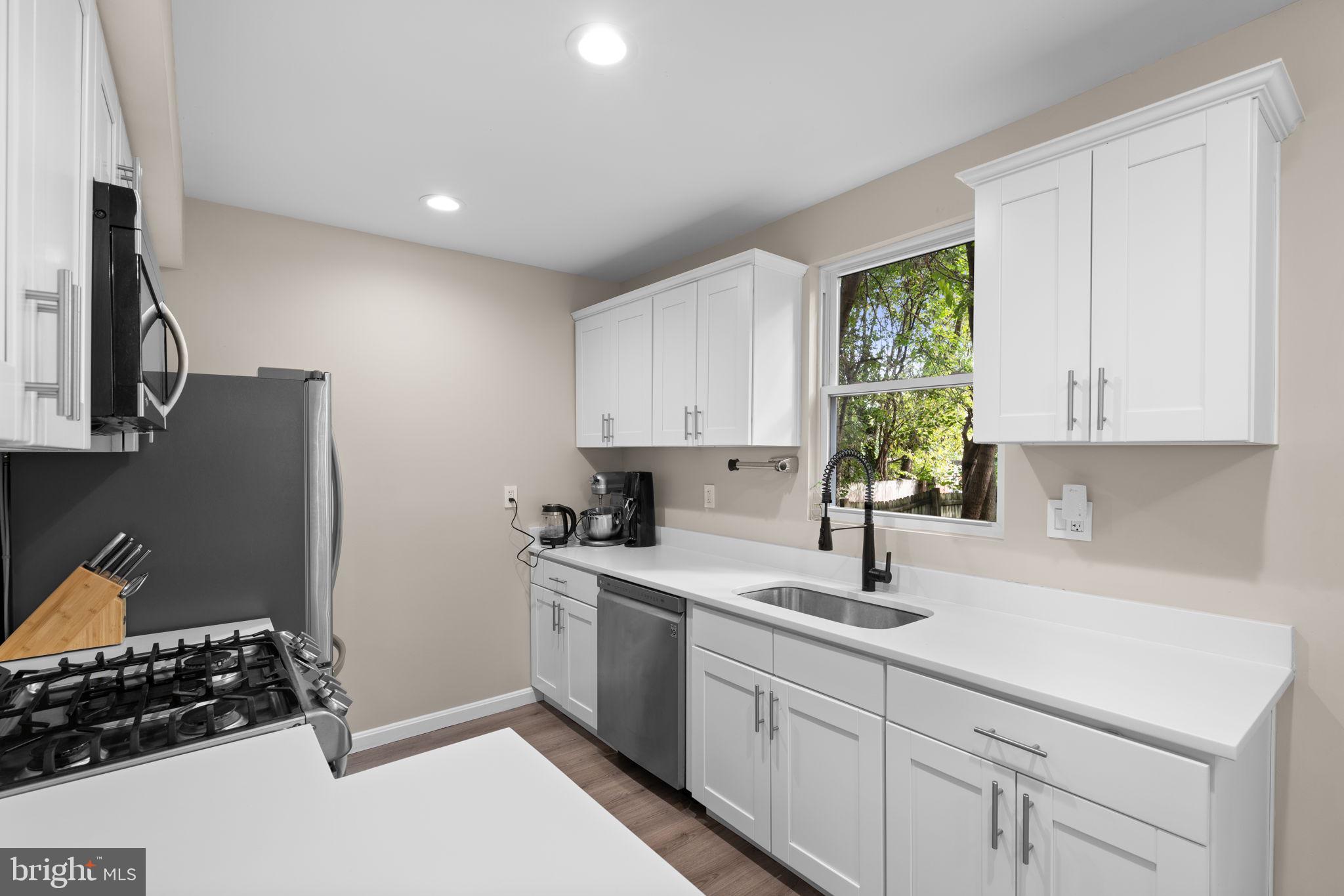 1015 48th Street Northeast Washington, DC 20019 - Photo 9 of 28 a kitchen with white cabinets and a stove