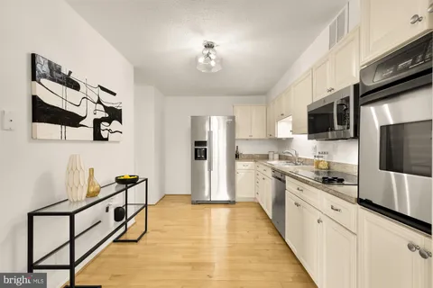 a kitchen with stainless steel appliances granite countertop a refrigerator and a stove top oven