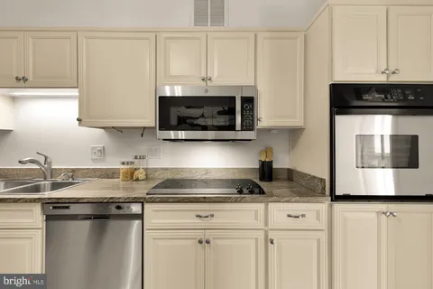 a kitchen with stainless steel appliances granite countertop a sink a stove and a microwave