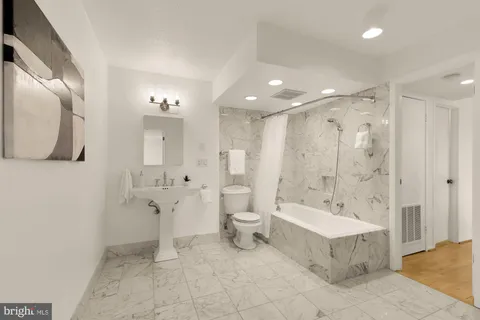 a spacious bathroom with a double vanity sink a mirror and a bathtub
