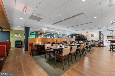 a view of a roof deck with table and chairs with wooden floor and fence