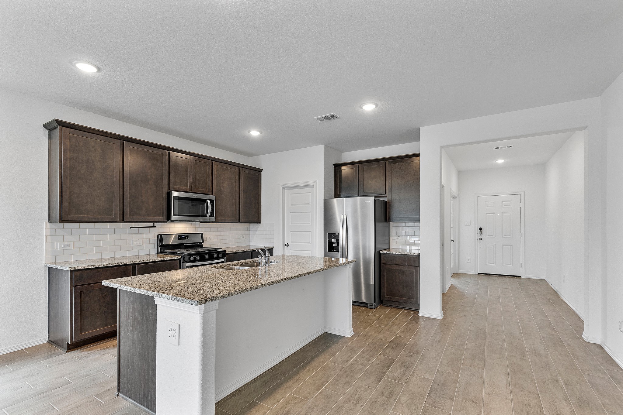9658 Caney Trails Road Conroe, TX 77303 - Photo 14 of 50 a kitchen with a refrigerator and a sink