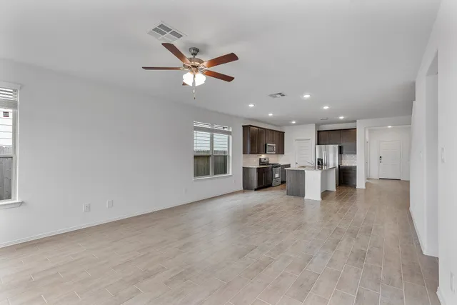 a view of a kitchen with a sink refrigerator wooden floor and a window