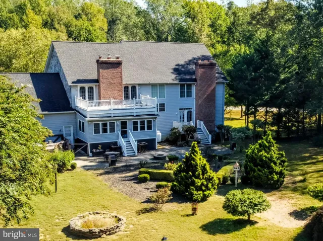 a aerial view of a house with swimming pool and large trees