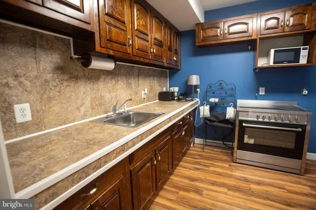 a kitchen with stainless steel appliances granite countertop a stove a sink and a microwave