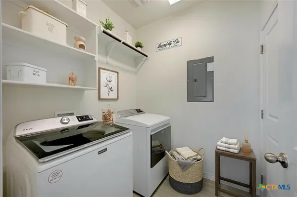 a utility room with dryer washer and a view of living area