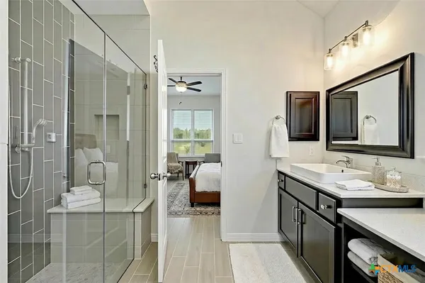 a en suite bathroom with a granite countertop sink mirror and double