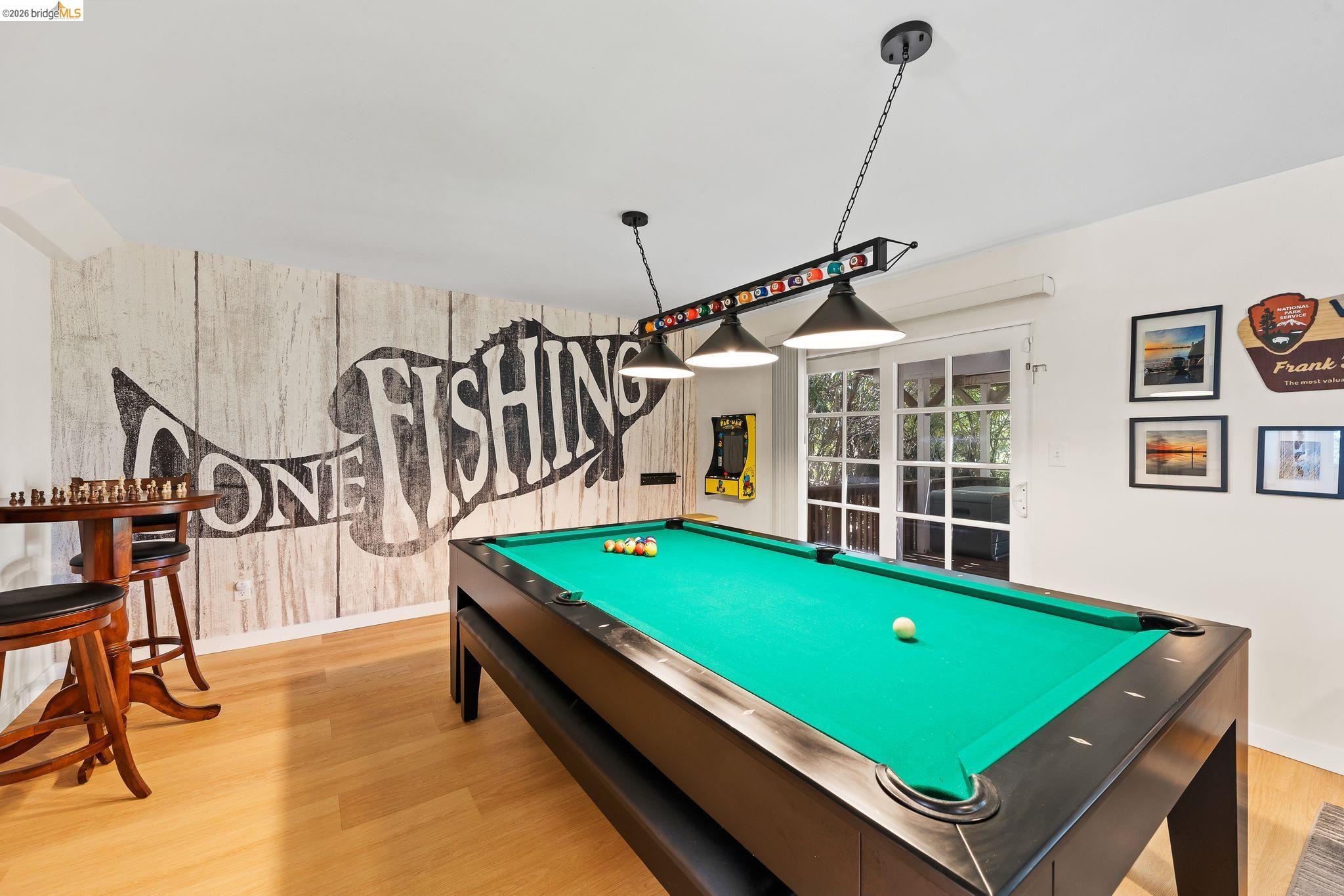 1704 Taylor Road Bethel Island, CA 94511 - Photo 12 of 73 Recreation room featuring wood-finish flooring, a decorative accent wall, and a set of French doors
