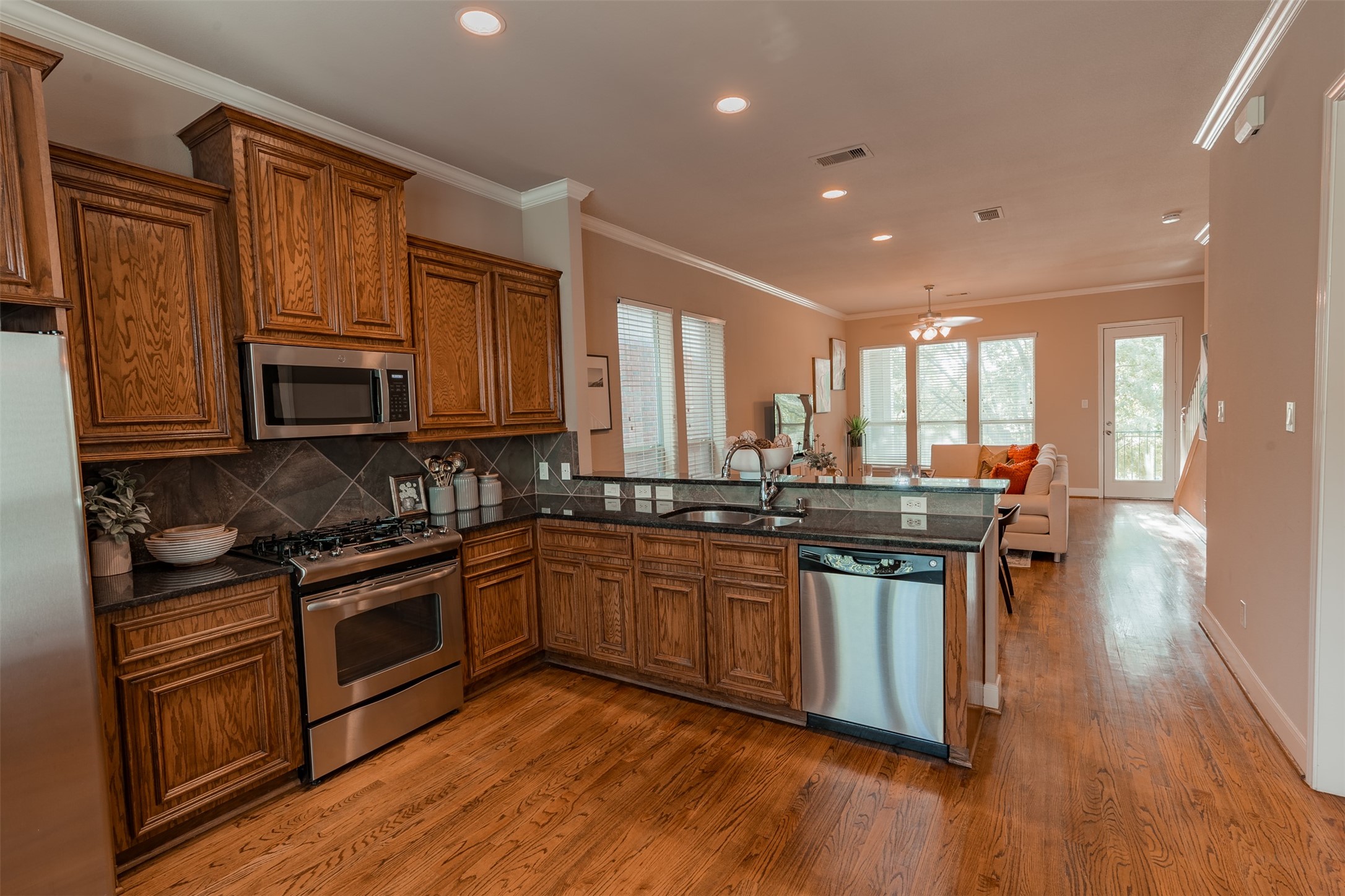 2354 Bastrop Street Houston, TX 77004 - Photo 6 of 21 a kitchen with stainless steel appliances granite countertop wooden cabinets and a stove top oven