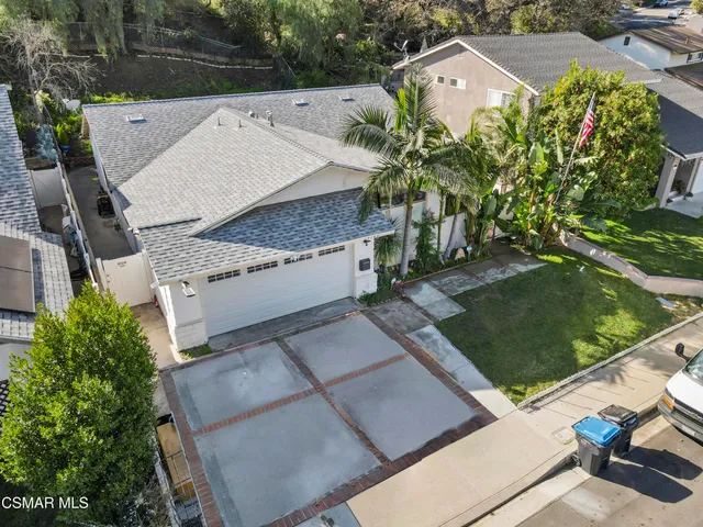 an aerial view of a house with a garden and lake view