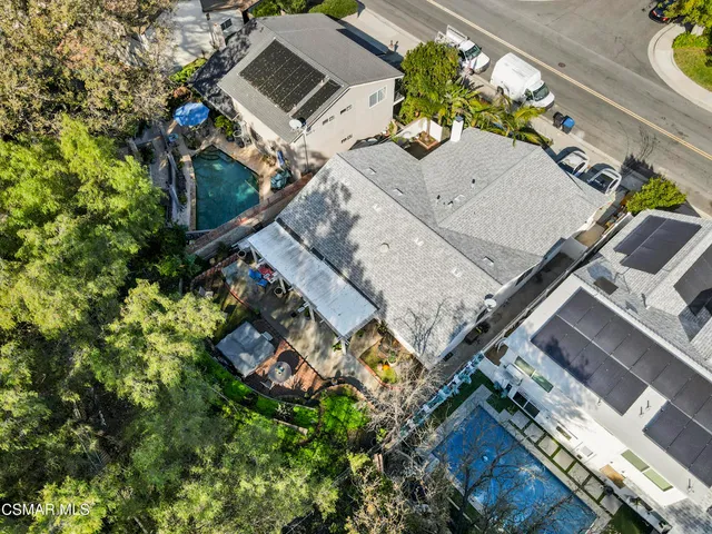 an aerial view of a house with a yard and a wooden deck