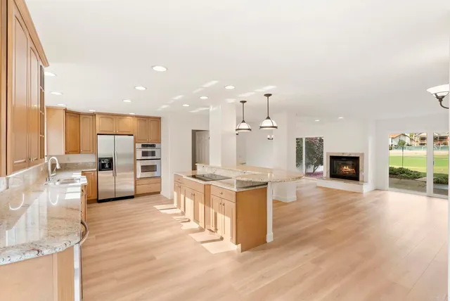 a large kitchen with kitchen island a large counter space a sink appliances and cabinets