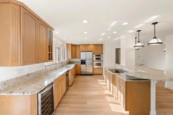 a kitchen with stainless steel appliances granite countertop a sink a stove and a wooden floor