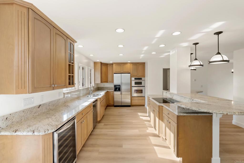 219 Via Osuna Rancho Santa Fe, CA 92091 - Photo 13 of 50 a large kitchen with kitchen island a large counter space a sink appliances and cabinets
